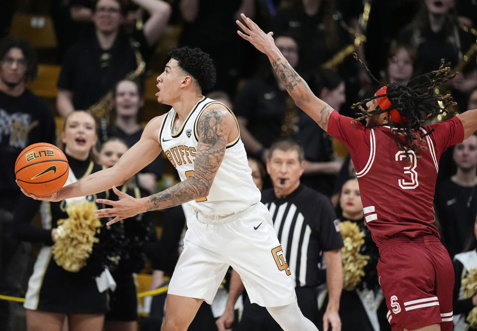 Colorado guard KJ Simpson, left, drives to the basket past Stanford guard Kanaan Carlyle (3) in the first half of an NCAA college basketball game Sunday, March 3, 2024, in Boulder, Colo. (AP Photo/David Zalubowski)