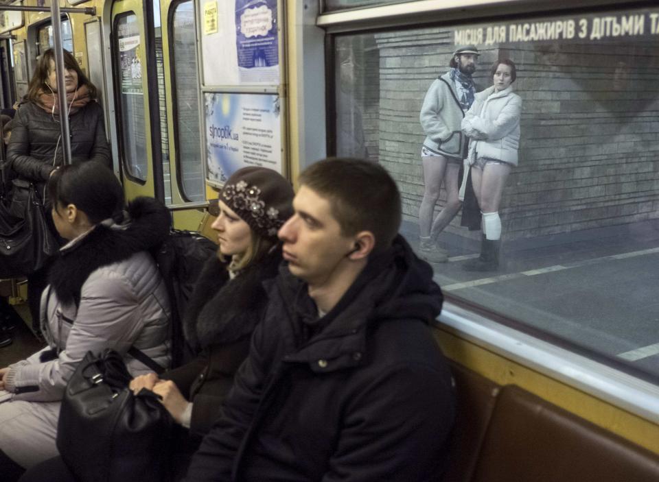 Passengers without pants wait on an underground platform during the "No Pants Subway Ride" in Kiev