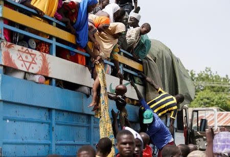 Parents lower their children from a loaded truck at a local bus station in Maiduguri, Borno State, Nigeria, August 30, 2016. REUTERS/Afolabi Sotunde