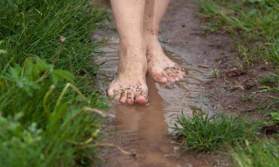 feet of a young woman walking barefoot through the puddles