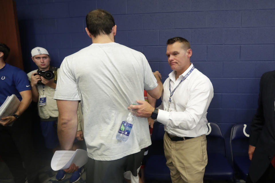 Indianapolis Colts quarterback Andrew Luck walks past Colts general manager Chris Ballard after a news conference following the team's NFL preseason football game against the Chicago Bears, Saturday, Aug. 24, 2019, in Indianapolis. The oft-injured star is retiring at age 29. (AP Photo/Michael Conroy)
