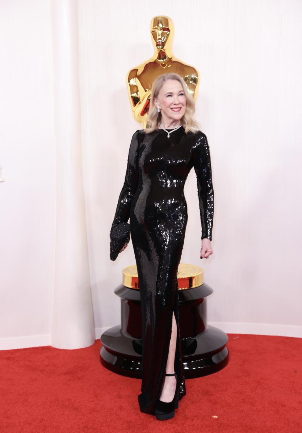 Catherine O'Hara wears a sequined black gown.