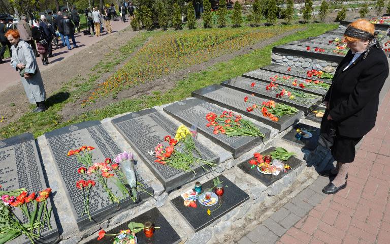 An elderly woman pays her respects to the victims of the Chernobyl nuclear disaster at a memorial in Kiev on April 26, 2015