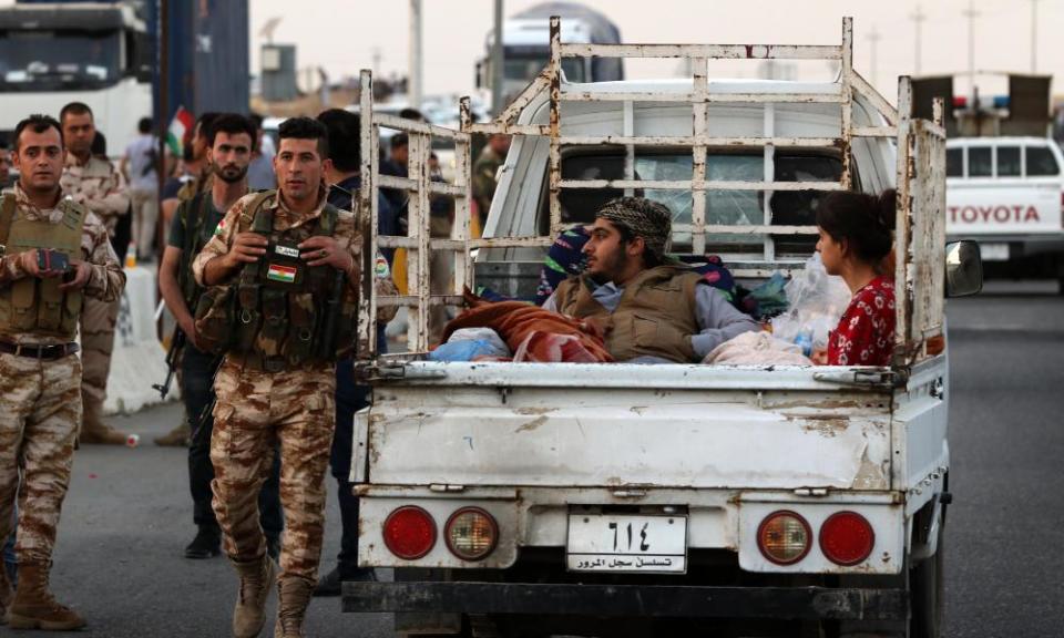 Iraqi families fleeing Kirkuk province cross a Kurdish checkpoint in Altun Kupri.