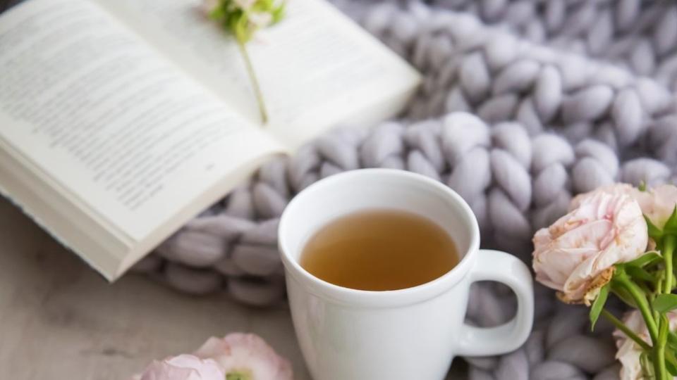 Una taza con una infusión y un libro