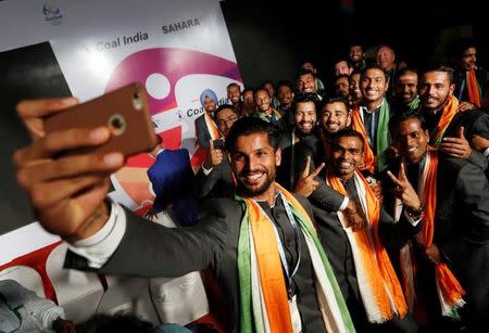 Indian men hockey team members, who will participate in the Rio 2016 Olympics, pose for a selfie during an introduction ceremony of the team, in New Delhi, India, July 12, 2016. REUTERS/Adnan Abidi/Files