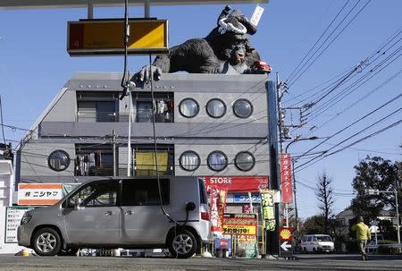A gorilla statue is seen on top of a building in front of a Shell petrol station in Tokyo, January 9, 2015. REUTERS/Toru Hanai