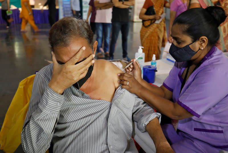 A man reacts as he receives a dose of the COVISHIELD coronavirus disease (COVID-19) vaccine, in Ahmedabad