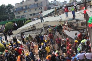 Rescue workers search for children trapped inside the collapsed Enrique Rebsamen school in Mexico City