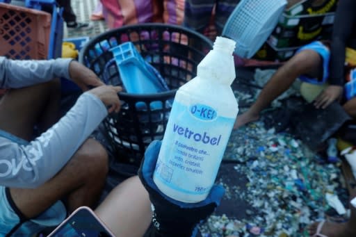 A volunteer holds a detergent plastic bottle collected on Isabela Island in the Galapagos archipelago in February 2019