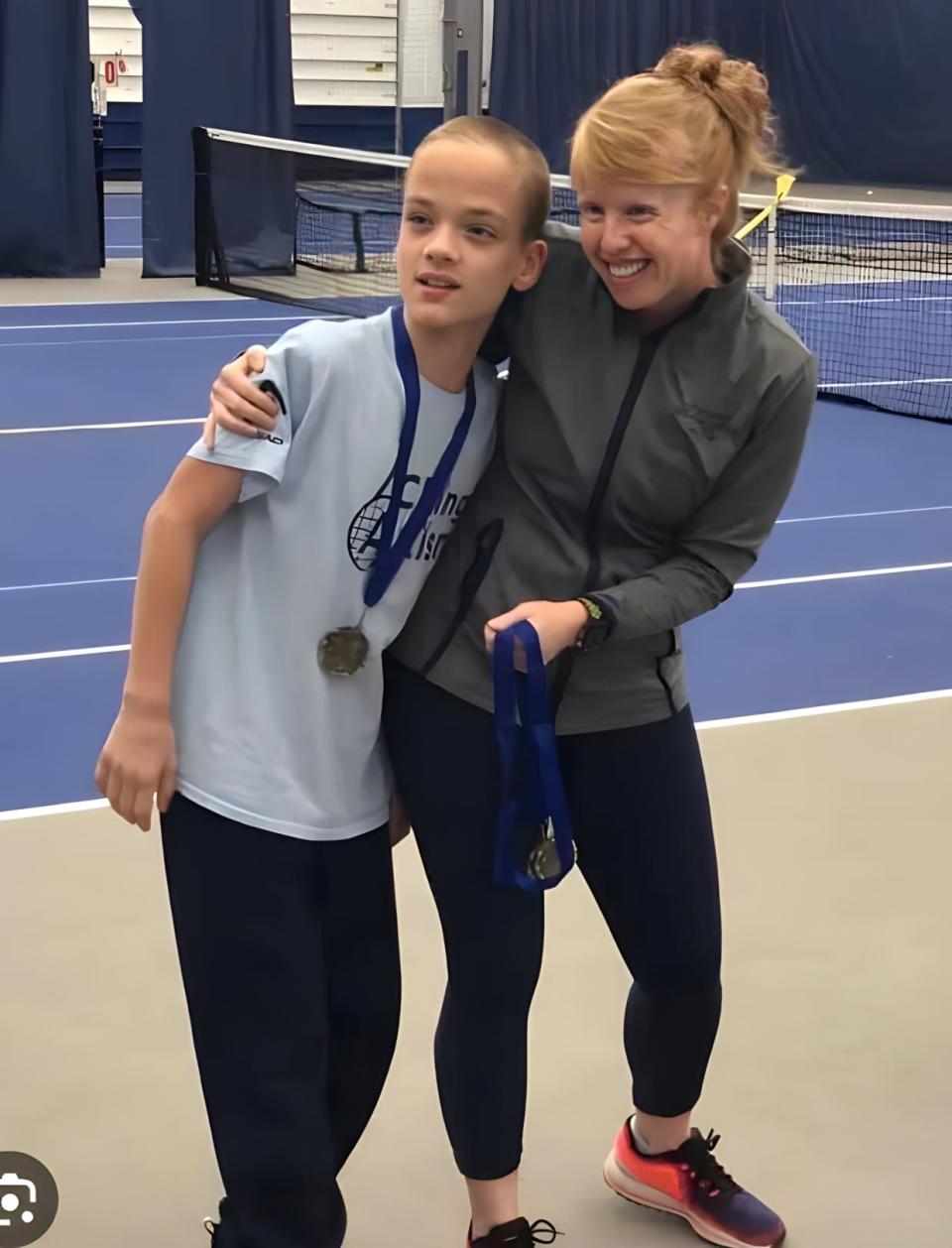Katie Orlando con uno de los niños con los que trabaja en el programa ACEing Autism en Towpath Tennis Center en Akron.