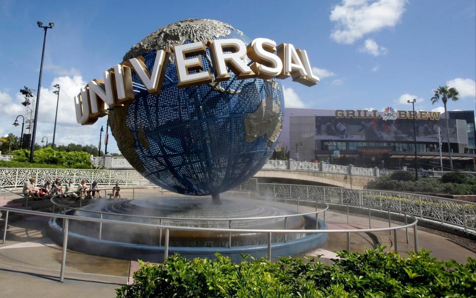 n this Thursday, Oct. 22, 2015 file photo, park guests relax and cool off with a water mist under the globe at Universal Studios City Walk in Orlando, Fla. Universal Orlando Resort and SeaWorld are the latest theme park resorts in Florida to again ask visitors to wear masks indoors, with Universal also ordering its employees to wear face coverings to protect against COVID-19, which has been surging across the state. All workers at Universal's Florida park on Saturday, July 31, 2021 started being required to wear masks while indoors as the employees returned to practicing social distancing.  - AP