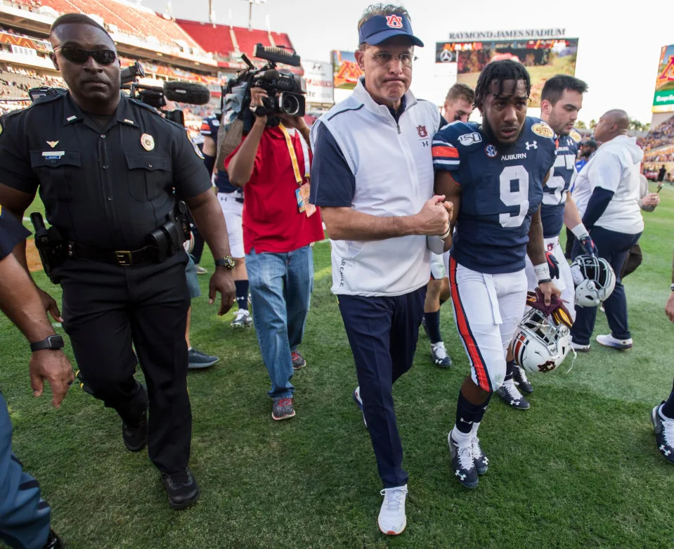 Auburn head coach Gus Malzahn and Auburn senior running back Kam Martin (9) walk off the field during the Outback Bowl at Raymond James Stadium in Tampa, Fla., on Wednesday, Jan. 1, 2020. Minnesota defeated Auburn 31-24.