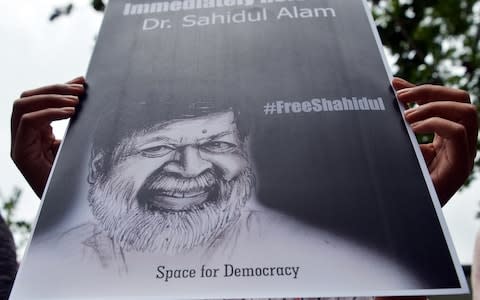 Sri Lankan activist holds a placard during a demonstration outside the Colombo High Commission of Bangladesh - Credit:  LAKRUWAN WANNIARACHCHI/AFP