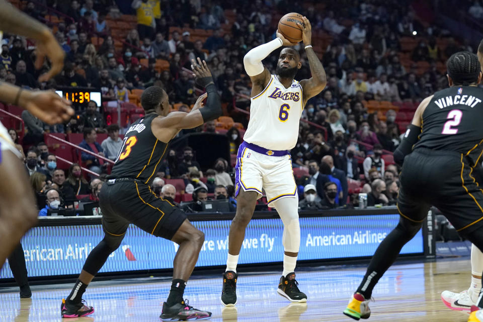 Los Angeles Lakers forward LeBron James (6) attempts a three-point basket as Miami Heat center Bam Adebayo defends during the first half of an NBA basketball game, Sunday, Jan. 23, 2022, in Miami. (AP Photo/Lynne Sladky)