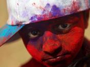 An underprivileged boy looks out, with his face smeared with colored powder during the Holi festivities in Mumbai, India, Friday, March 18, 2011. Holi, the Hindu festival of colors is celebrated by people throwing coloured powder and coloured water at each other and will be marked across the country on March 20. (AP Photo/Rafiq Maqbool)