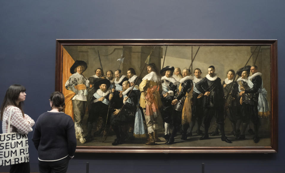 People admire Frans Hals' Militia Company of District XI under the Command of Captain Reynier Reael, known as 'The Meagre Company', at the Rijksmuseum in Amsterdam, Netherlands, Tuesday, Feb. 13, 2024. Frans Hals is the latest 17th century Dutch master to feature in a major exhibition at the Rijksmuseum in Amsterdam. A show opening on Wednesday highlights Hals' lose brush strokes that made him a forerunner of the impressionist movement. (AP Photo/Michael Corda)