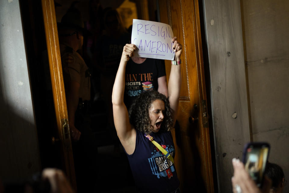 A demonstrator leaves the gallery holding a sign calling for House Speaker Cameron Sexton, R-Crossville, to resign during a special session of the state legislature on public safety Monday, Aug. 28, 2023, in Nashville, Tenn. (AP Photo/George Walker IV)