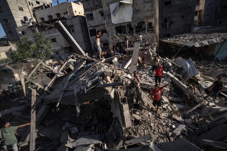 Palestinians look at the destruction after Israeli strikes on the Gaza Strip in Khan Younis (Copyright 2023 The Associated Press. All rights reserved.)