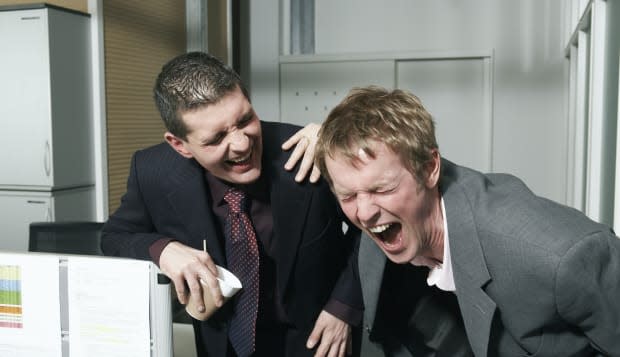 Two businessmen taking break in office, laughing