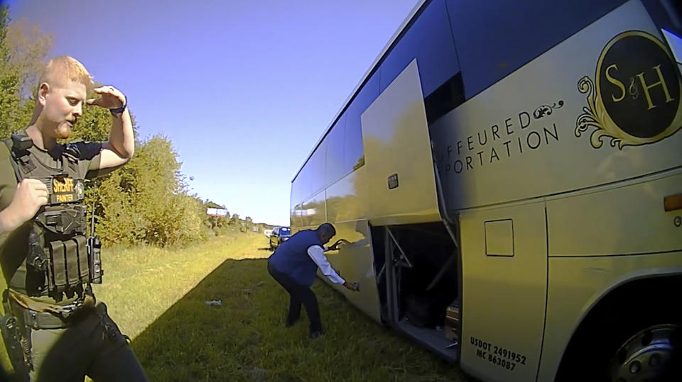 In this screenshot of a video released by Spartanburg County Sheriff's Office, a bus driver opens the storage doors for law enforcement officers on Oct. 5, 2022, after officers in Spartanburg County, S.C., stopped a contract bus transporting students from Shaw University in Raleigh, N.C., to a conference in Atlanta. The historically Black university in North Carolina announced Monday, Nov. 21, 2022 that it has filed a complaint with the Department of Justice seeking a review of a search of a bus carrying students during a traffic stop in South Carolina last month. (Spartanburg County Sheriff's Office via AP)