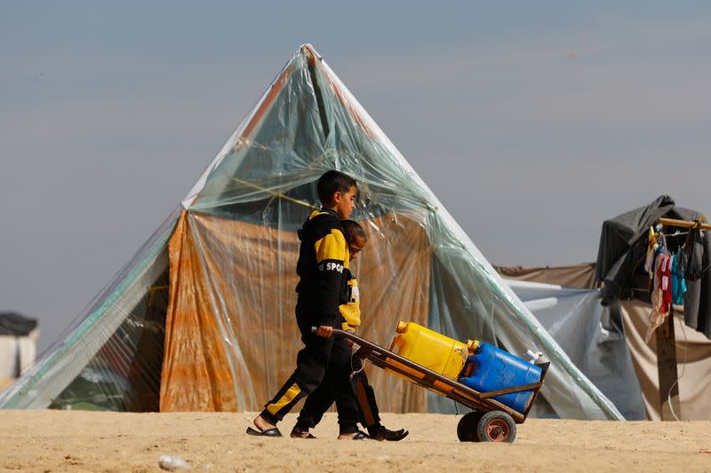 Displaced Palestinians, who fled their houses due to Israeli strikes, take shelter in a tent camp in Rafah