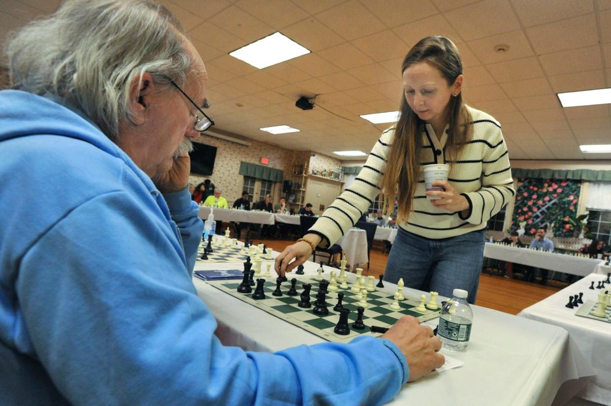 Chess Grandmaster Nadya Kosintseva, right, moves a piece as she competes with John Tempesta of Quincy, right, during a simul amateur chess competition at the South Shore Chess Club in Quincy, Wednesday, March 28, 2024.