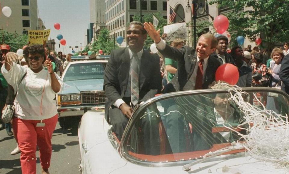 Charlotte mayor Harvey Gantt (left) and team owner George Shinn wave to the crowds during a parade in uptown Charlotte in 1987 that celebrated the city acquiring the rights to an NBA franchise that would be called the Hornets.