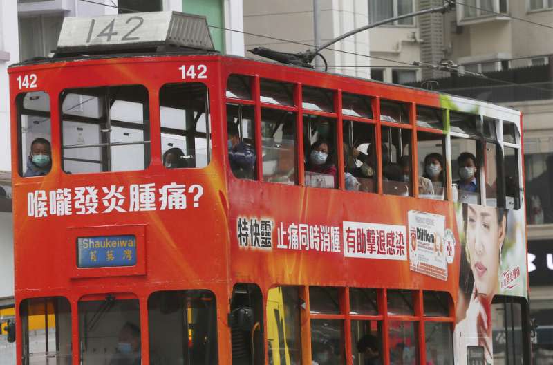 武漢肺炎疫情肆虐，香港叮叮車上的乘客大多也戴著口罩。（美聯社）