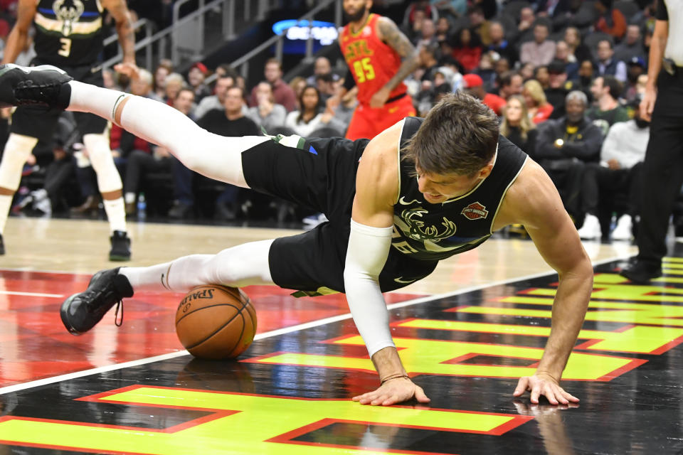 Milwaukee Bucks guard Kyle Korver (26) tries to save a ball from going out of bounds during the second half of an NBA basketball game against the Atlanta Hawks, Friday, Dec. 27, 2019, in Atlanta. (AP Photo/John Amis)