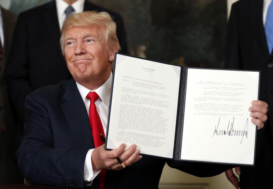 President Donald Trump holds up a signed memorandum calling for a trade investigation of China on Monday, Aug. 14, 2017 in Washington. (AP Photo/Alex Brandon)