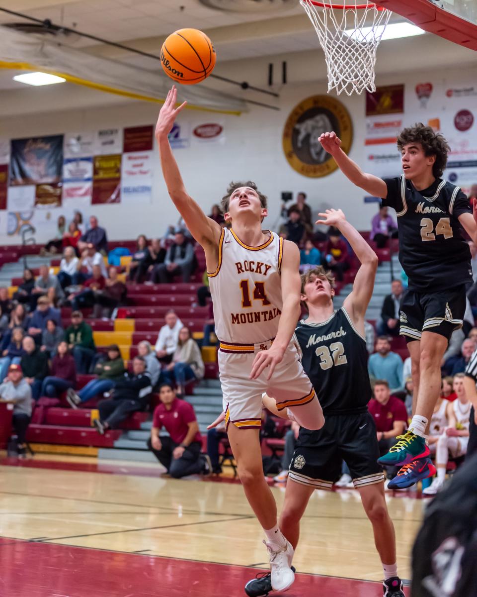 Rocky Mountain boys basketball player Parker Davis scoops a layup around Monarch defenders during a game against Monarch on Jan. 17 at Rocky Mountain High School in Fort Collins.