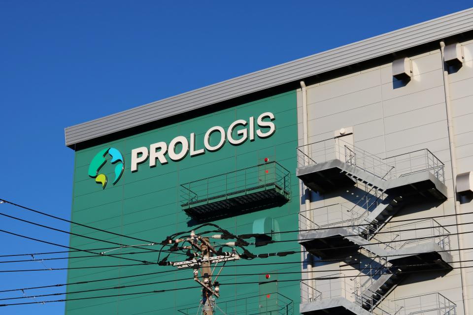 A Prologis sign on the side of a green warehouse.