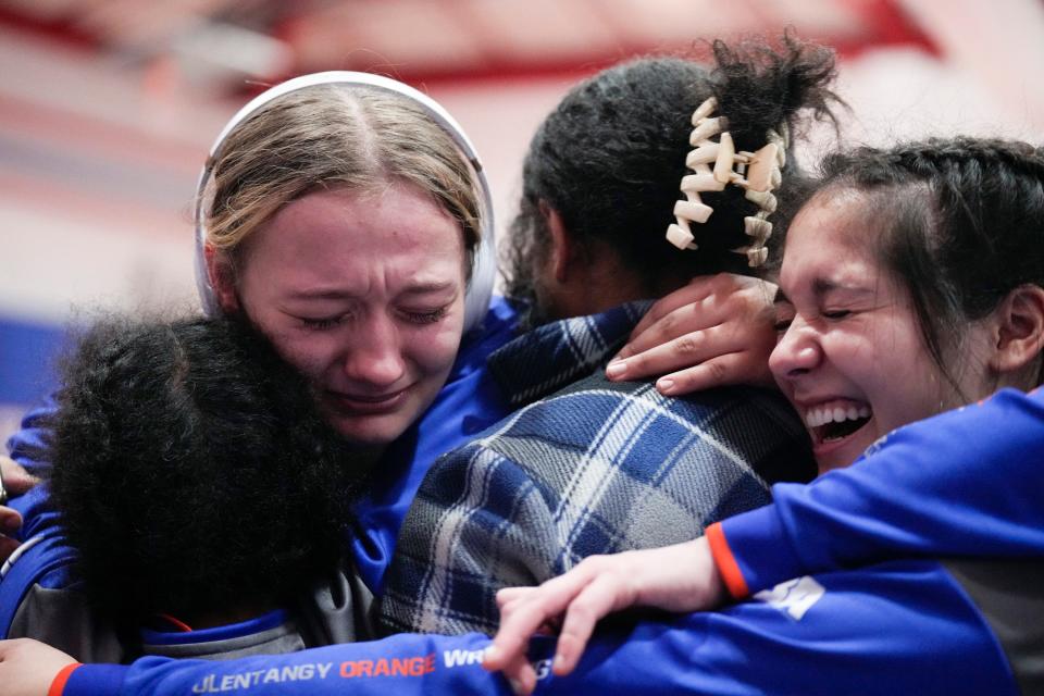 Olentangy Orange’s Alicia Coleman, left, and Surraiya Mahmud, right, celebrate with teammates during the girls wrestling state dual tournament Sunday at Marysville. The Pioneers defeated Marysville 42-36 to win their second consecutive title.