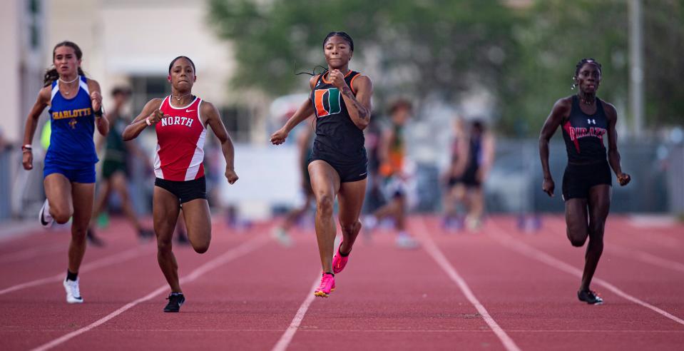Kayla Hopkins, center,  from Dunbar wins the 100 meters during the FHSAA 3A District 11 track & field meet at Dunbar High School on April 20, 2023.   