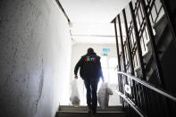 Pastor Bernd Siggelkow founder of the Christian charity the Arche, or Ark, carries bags with donated goods for poor families up the stairs of a center of the organization in Berlin, Germany, Tuesday, March 31, 2020. The group that provides help to about 1,300 poor families across Germany is now delivering food, hygiene products and children’s games to their doorstep during the coronavirus outbreak. (AP Photo/Markus Schreiber)