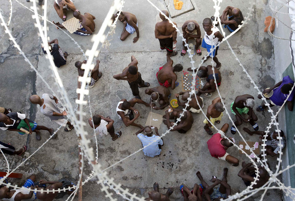 <p>Prisoners play dominoes, checkers or card games, during recreation time inside the National Penitentiary in downtown Port-au-Prince, Haiti, Feb. 13, 2017. Inmates, some waiting up to eight years to see a judge, try to keep their sanity by maintaining a daily routine of push-ups and lifting jugs filled with dirty water. Others play checkers or dominoes. (Photo: Dieu Nalio Chery/AP) </p>