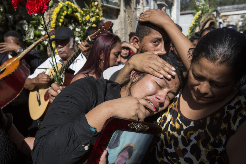 FILE - In this March 17, 2017 file photo, Shirley Palencia weeps during the burial service for 17-year-old sister Kimberly Palencia Ortiz, who died in the Virgen de la Asunción Safe Home fire, at the cemetery in Guatemala City. Authorities said the fire that swept through parts of the institution when mattresses were set ablaze during a protest by girls protesting conditions at the overcrowded youth shelter. (AP Photo/Moises Castillo, File)