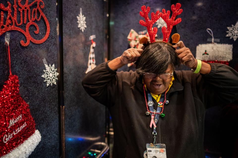 Elevator attendant Martha Booker puts on reindeer antlers before a game between the Nashville Predators and the Dallas Stars at Bridgestone Arena in Nashville, Tenn., Saturday, Dec. 23, 2023.