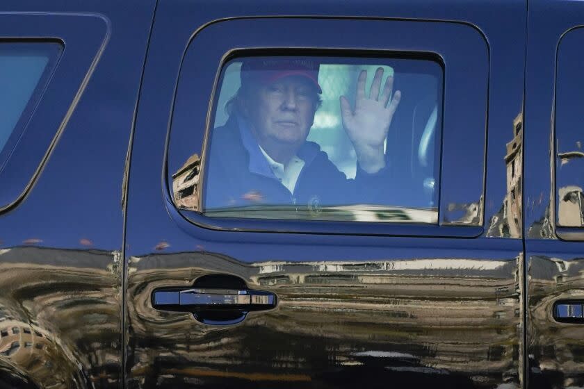 El presidente Donald Trump saluda a manifestantes desde uno de sus vehículos en caravana en Washington el 14 de noviembre de 2020. (AP Foto/Julio Cortez)