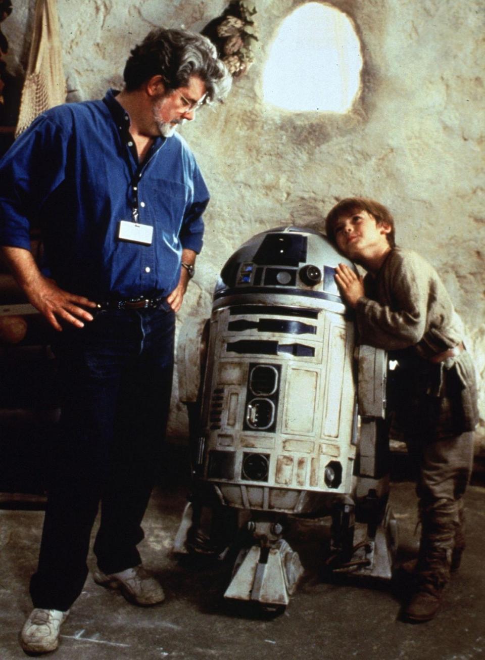 <p>George Lucas mit R2-D2 und Anakin-Skywalker-Darsteller Jake Lloyd am Set von “Die dunkle Bedrohung” (Bild: ddp images) </p>