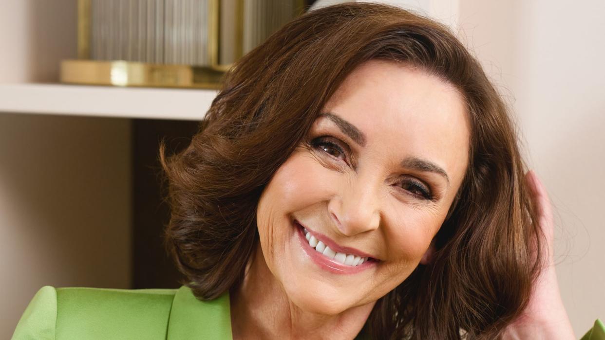 Shirley Ballas smiling in a green suit