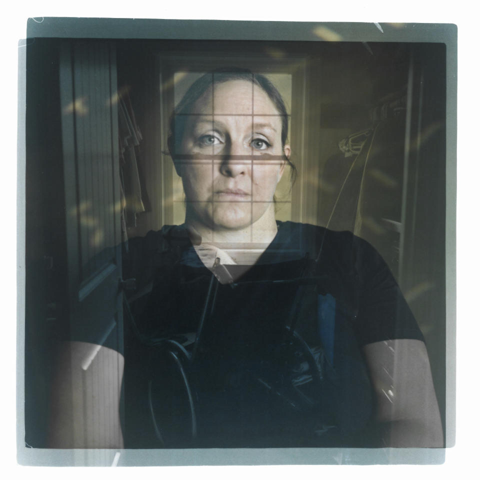 In this double exposure darkroom print made from two film negatives, a portrait of Missy Jenkins Smith, a survivor of a school shooting in 1997 which left her paralyzed, is layered with a photo of her wheelchair she uses for showering as it sits in her closet at her home in Kirksey, Ky., Monday, June 5, 2023. Even after two and a half decades, Jenkins Smith still recalls the moment in exacting detail. That night, she and husband, Josh, had taken their son to Chuck E. Cheese to celebrate his third birthday. On the drive home, he asked, "Mom, why are you in a wheelchair?" Jenkins Smith never had a choice about whether to keep what had happened to her hidden. Paralyzed from the chest down when one of the shooter's bullets severed her spinal cord, she had been honest with herself and others about the injury and the circumstances. In a way, talking about it was like therapy, she says. But that was very different from explaining it to a small child. Her child. (AP Photo/David Goldman)