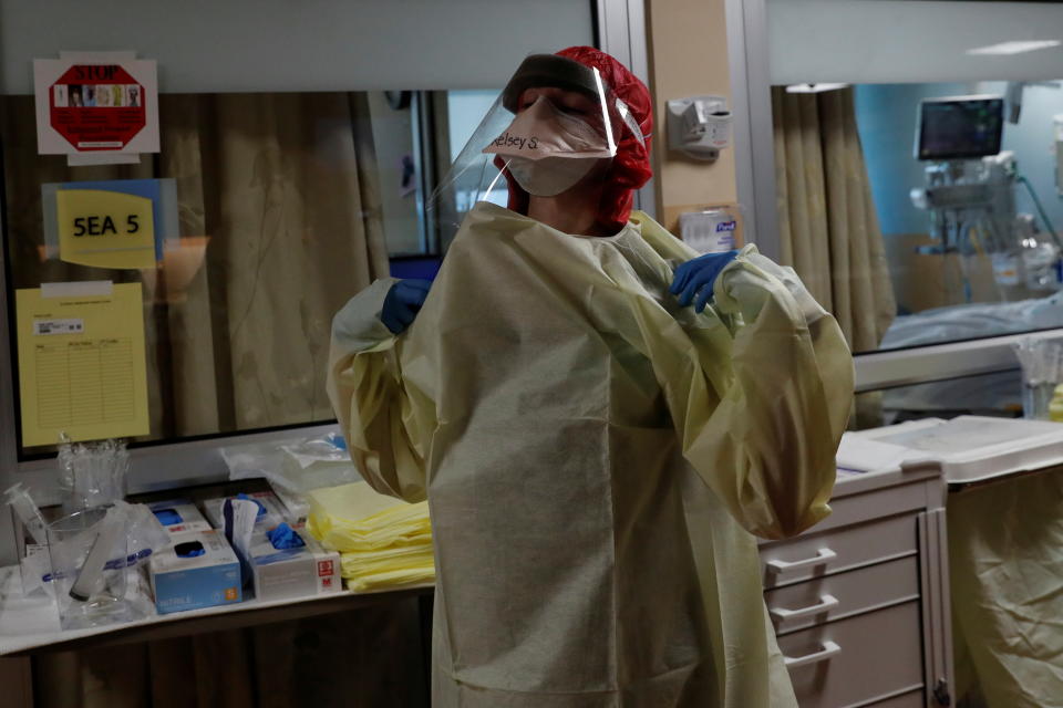 Registered nurse Kelsey Simons pauses while putting on her personal protective equipment (PPE) gear before treating a coronavirus disease (COVID-19) positive patient inside their isolation room in the intensive care unit (ICU) at Sarasota Memorial Hospital in Sarasota, Florida, U.S., September 21, 2021. REUTERS/Shannon Stapleton