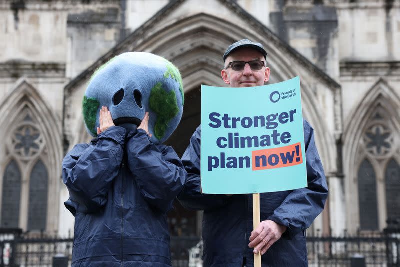 Environmental campaigners stand outside the High Court in London