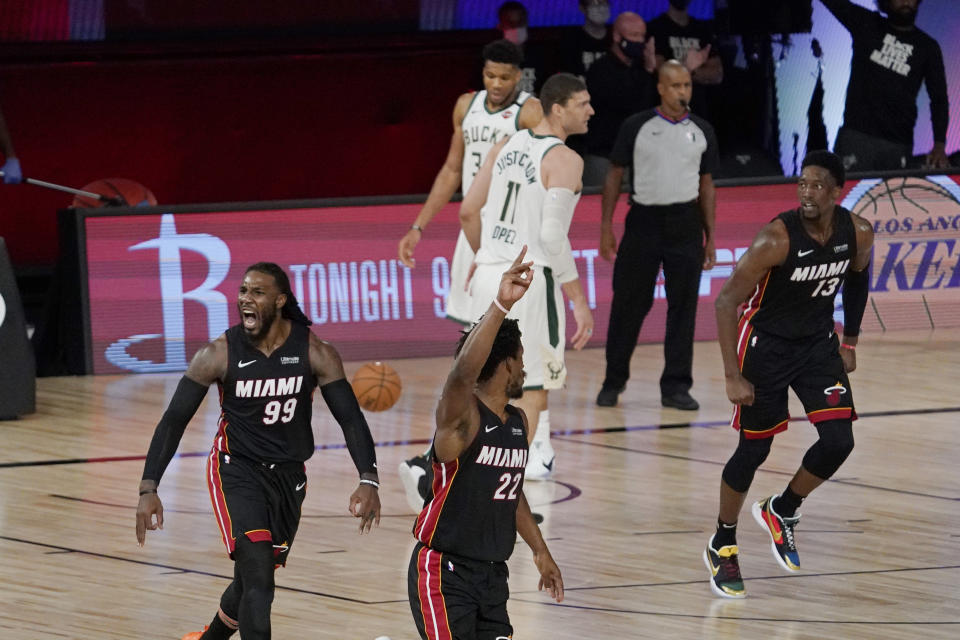 Miami Heat's Jae Crowder (99), Jimmy Butler (22) and Bam Adebayo (13) celebrate as they run up the court in front of Milwaukee Bucks' Brook Lopez (11) and Giannis Antetokounmpo (34) after a basket in the second half of an NBA conference semifinal playoff basketball game Friday, Sept. 4, 2020, in Lake Buena Vista, Fla. (AP Photo/Mark J. Terrill)