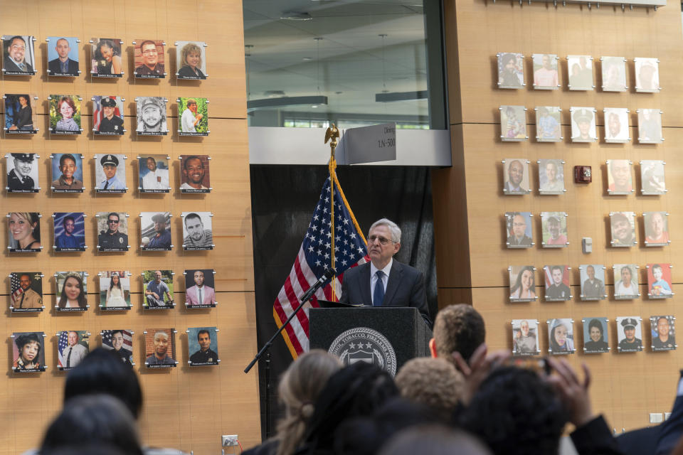 Attorney General Merrick Garland speaks next to a wall with photographs of victims of gun violence during the Inaugural Gun Violence Survivors' Summit at ATF Headquarters in Washington, Tuesday, April 23, 2024. (AP Photo/Jose Luis Magana)