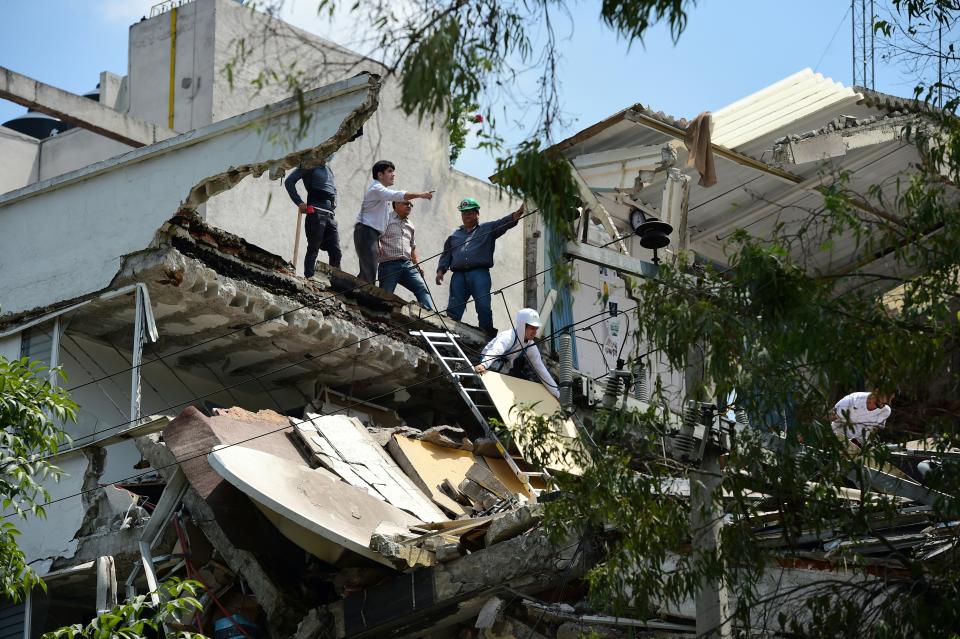 <p>Un grupo de personas sobre un edificio que colapsó en Ciudad de México luego de que la ciudad fuese golpeada por un sismo de 7,1 grados (AFP | Ronaldo Schemidt) </p>