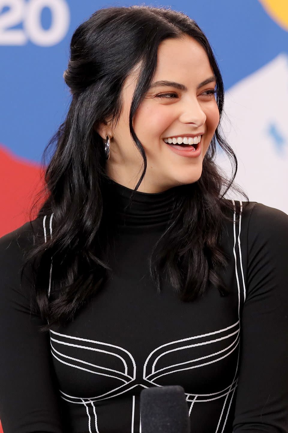 <p>Camila Mendes wears her hair in loose curls, with some gathered at the back and short layers out front to frame her face. </p>