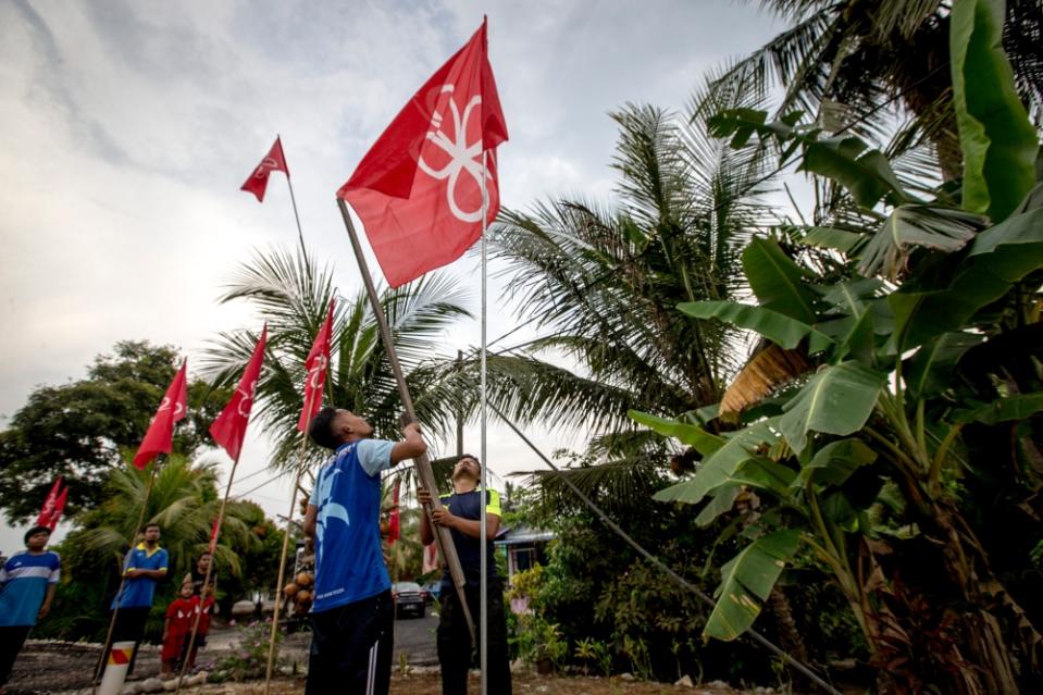 File picture of a supporter installing Bersatu flags in Ayer Hitam in Johor ahead of the 14th general election, April 5, 2018. — Picture by Firdaus Latif